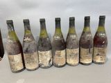 six bottles of wine are lined up in a row on a table