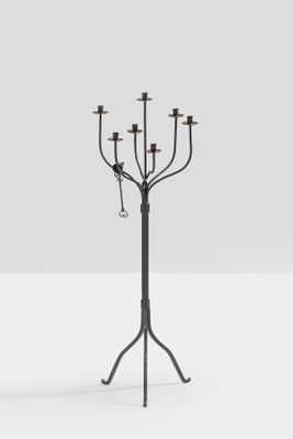 a black metal candelier with five candles on a stand