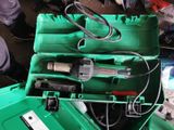 a green box with tools inside of it on the floor