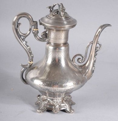 une théière ancienne en argent surmontée d'un oiseau