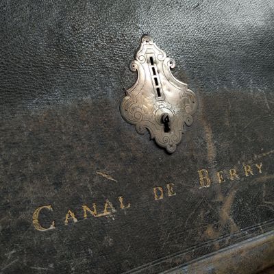 une boîte métallique munie d'un cadenas sur laquelle est inscrit « Canal de Berry »