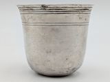 a silver cup on a white surface with a white background