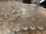 many glasses on the table with a bottle of wine in the middle