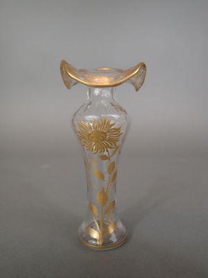 a glass vase that has a gold decoration on it