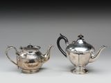 deux théières en argent et un sucrier posés sur une table