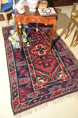 un tapis posé à même le sol dans une pièce où se trouvent des chaises et une table