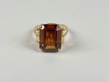 Gros plan sur une bague contenant une pierre orange