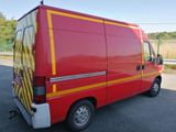 a red van with yellow stripes parked in a parking lot