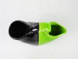 a black and green vase sitting on a white table