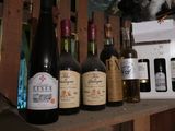 several bottles of wine are lined up on a shelf in a room