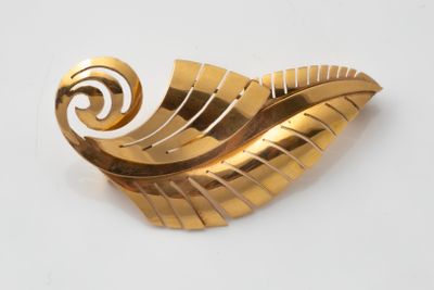 an image of a gold brooch with a spiral design on it