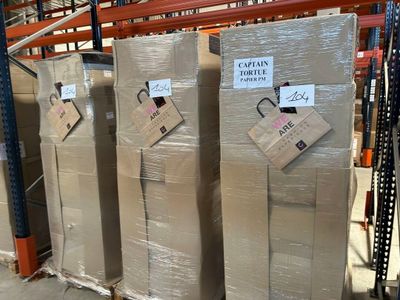 quatre réfrigérateurs empilés sur des palettes dans un entrepôt