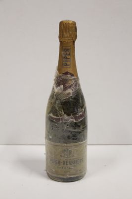 an old bottle of champagne sitting on top of a white table
