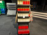 many cans of red and white paint on the shelves