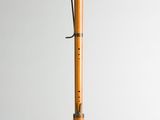a wooden flute with a black handle and a white background