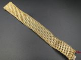 a close up of a gold bracelet on a black surface