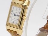 an image of a watch with a gold case and brown leather strap