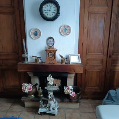 a clock on the wall above a fireplace in a living room