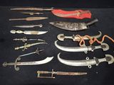 many different types of knives on a black table