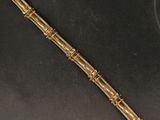un bracelet en or orné d'un motif de bambou