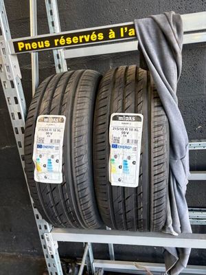 two tires on a rack in a garage with a sign on the wall