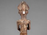 a wooden statue of a man with a hat on his head