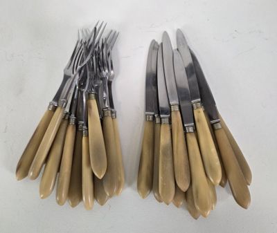 a lot of forks and knives on a white table