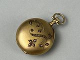 une montre de poche en or sertie de diamants, posée sur un fond blanc