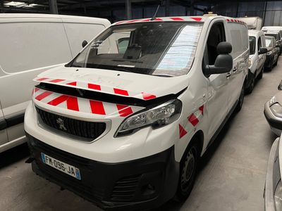 une camionnette blanche avec des bandes rouges et blanches garée dans un parking
