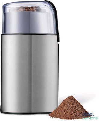 un moulin à café à côté d'un tas de grains de café