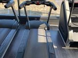 two tread machines in a gym room with a view of a field