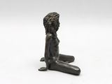 a close up of a figurine of a child sitting on the ground