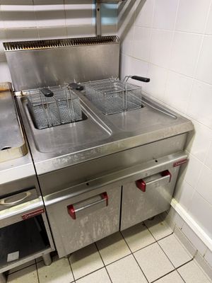 two deep fryers on the counter in the kitchen