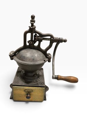 an old coffee grinder with a wooden handle on a white background
