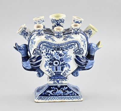 un vase bleu et blanc dans lequel se trouve un bouquet de bougies
