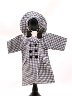 une poupée vêtue d'un manteau et d'un chapeau