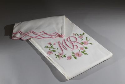 broderie sur un mouchoir blanc orné de fleurs roses et d'un monogramme
