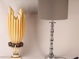 une lampe posée à côté d'un vase contenant une fleur