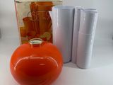 an orange vase and a pair of scissors next to it