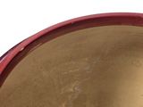 a close up of a red bowl on a white surface
