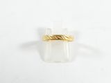 gros plan d'une bague en or sur une surface blanche