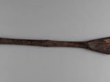 an old wooden spoon with a star on it sitting on a white surface