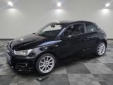 la voiture noire est garée sur un sol en damier dans le garage