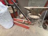 a hammer, an anvil, and a bag of sand on the ground