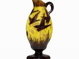 a yellow vase with black birds on it on a white surface