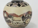 a vase with a picture of a man driving a horse drawn carriage