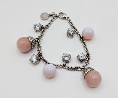 a close up of a bracelet with pink beads and charms on it