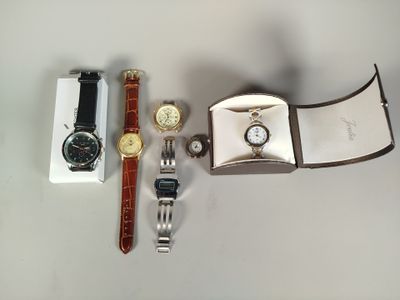 trois montres et un coffret à montres posés sur une table