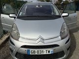 une Citroën argentée garée sur un parking près d'une clôture