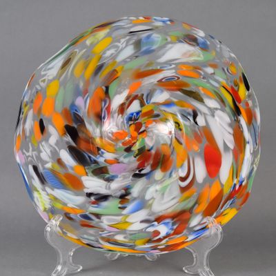 une image représentant un bol en verre multicolore posé sur un socle